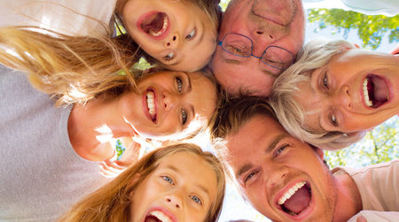 Familie schaut von oben in die Kamera